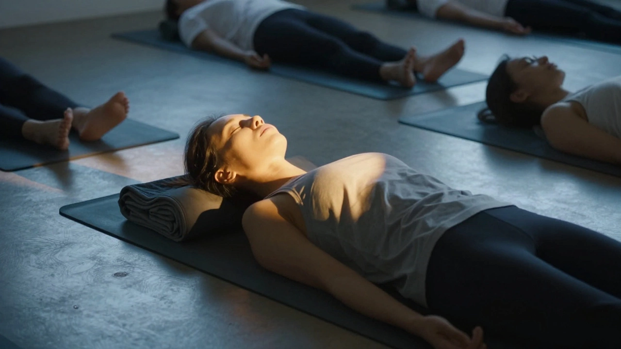 Person resting in Savasana with blanket and eye pillow, bathed in golden light.